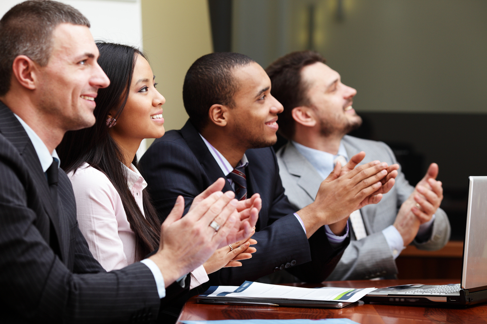 group of business employees smiling and clapping